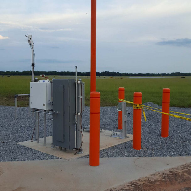 A field with orange posts and wires on the ground.