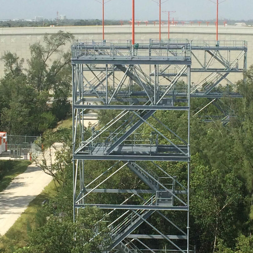 A metal tower with trees in the background